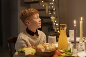 Niño sentado en la mesa comiendo.