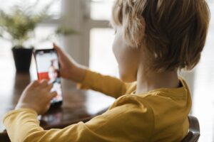 Niño usando redes sociales exponiéndose a graves riesgos.